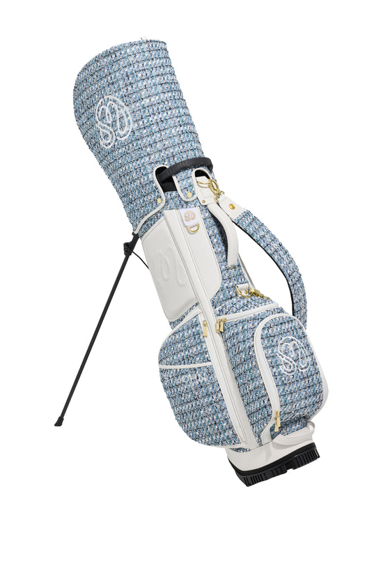 Blue and white textured St John Knits Malbon luxury golf bag with club on a white background